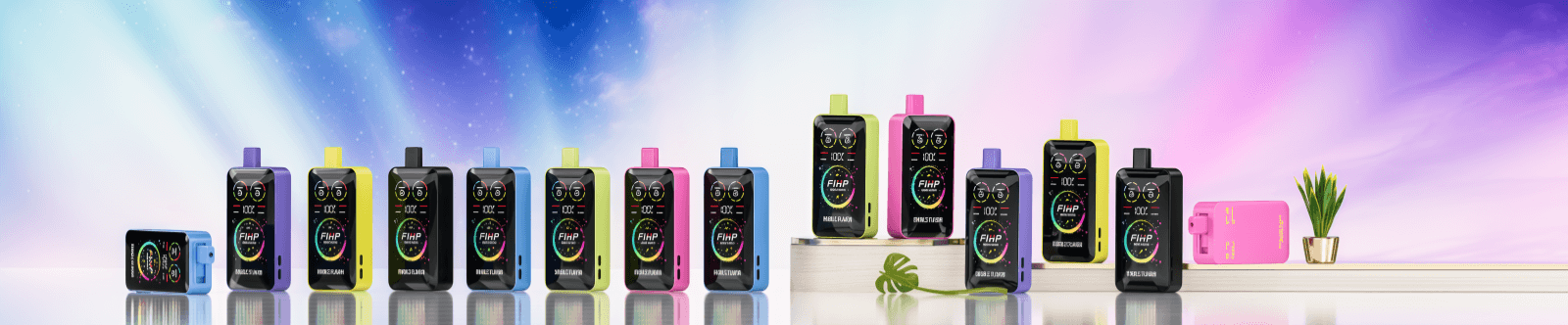 Lineup of colorful rectangular vaping devices with round digital display faces and top mouthpieces arranged on a reflective surface in front of a soft pastel gradient backdrop, with one unit lying on its side and a small potted plant and green leaf accenting the scene.